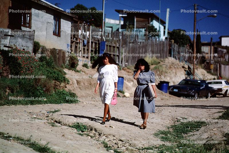 women walking, dirt street, homes, houses, Colonia Flores Magone