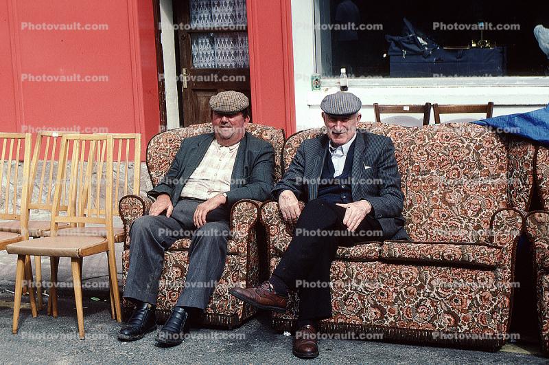 two men sitting on a sofa, two men sitting on a sofa