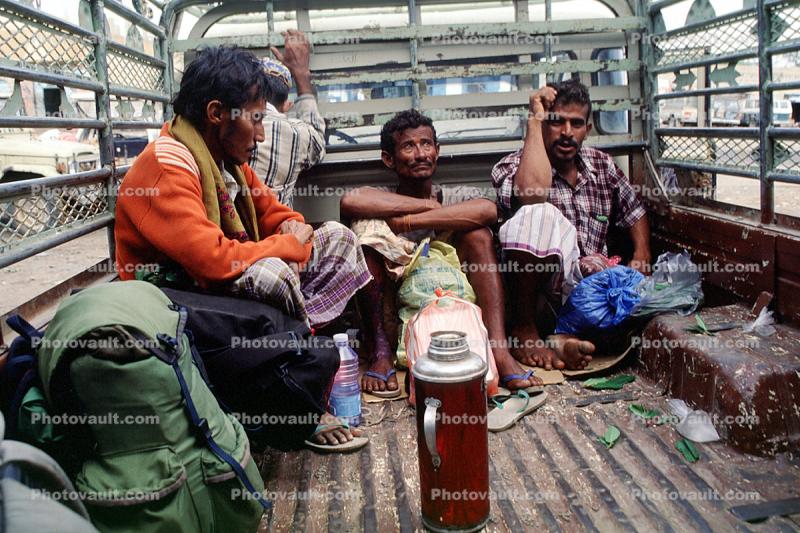 Men sitting in a jitney truck, thermos bottle, backpack, Yemen