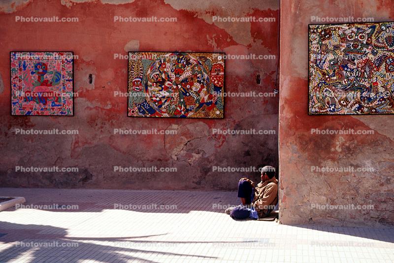 Wall with artwork, man sitting