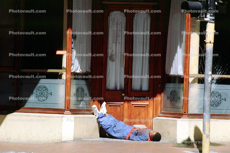 Man sleeping on the sidewalk, door, curtains, Johannesburg, South Africa