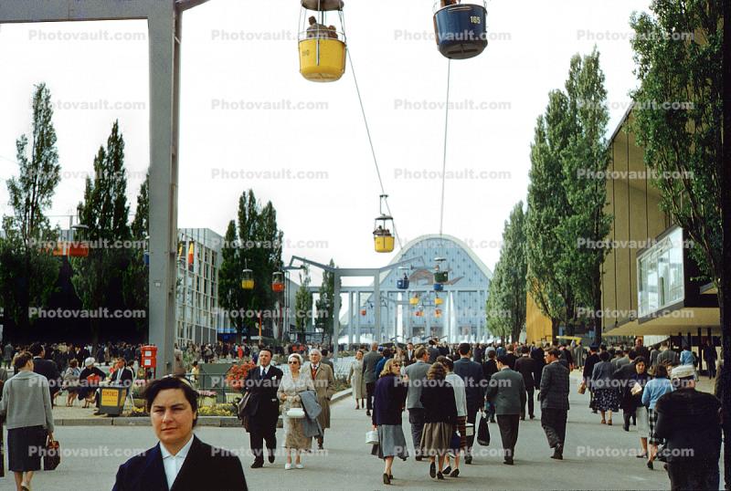 People Walking with Aerial Tram Overhead