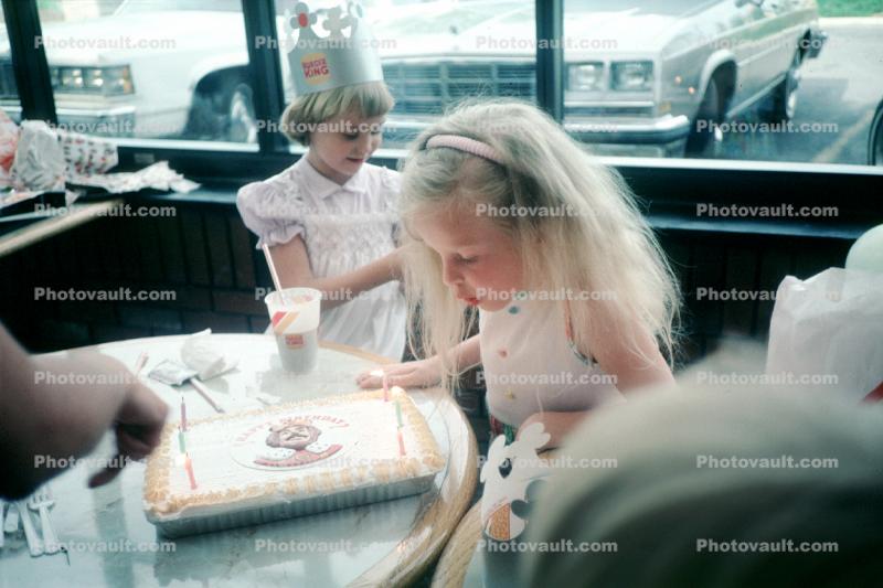 Girl Blowing out a Birthday Cake, making a wish, 1970s