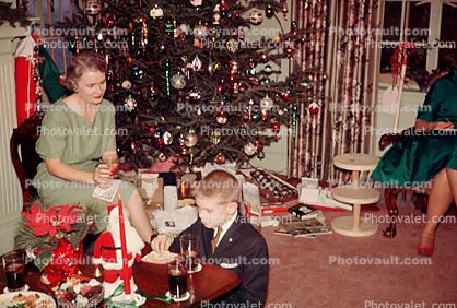 Woman, tree, decorations, poinsettia, boy, presents, 1940s