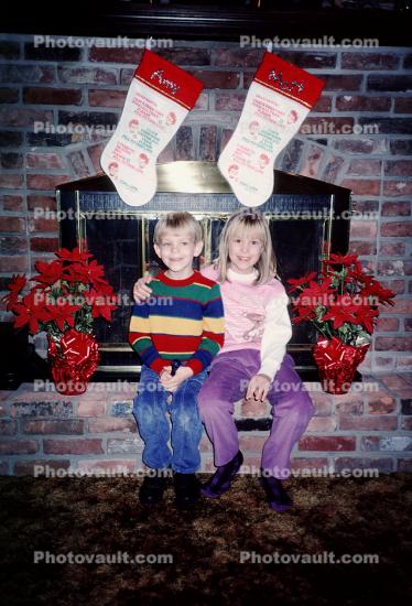 girl, boy, brother, siblings, stockings, fireplace, brick, poinsettia