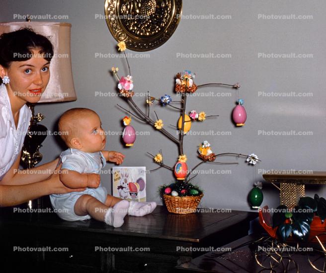 Baby looking at an Easter Tree, eggs, decorations, toddler, mother, 1950s