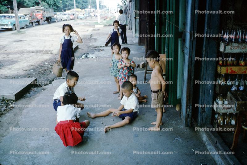 Playing Marbles, boys, girls, sidewalk, Bangkok Thailand, October 1962, 1960s