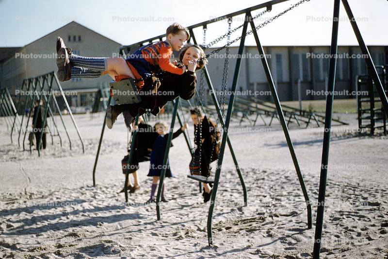 Swingset, swings, girl, boy, sand, 1940s
