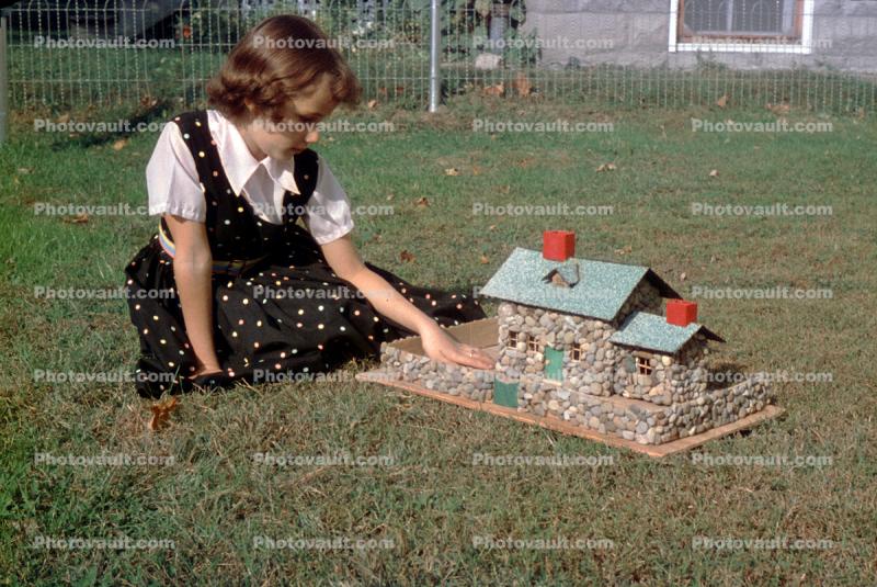 Girl plays with doll house, 1950s