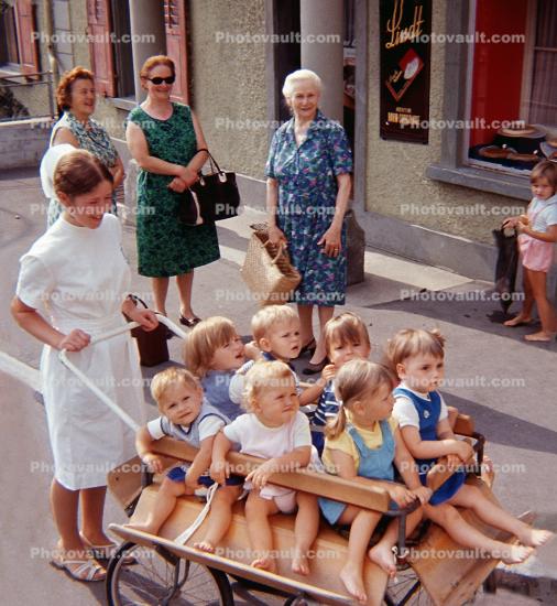 Nurse Maid, cart full of kids, boys, girls, barefeet, barefoot, Hergiswil Switzerland, August 1970, 1970s