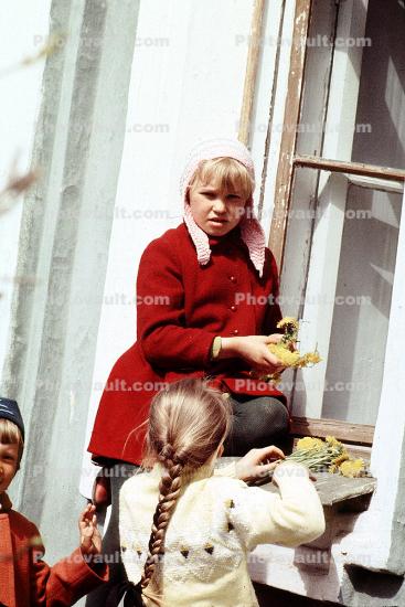 Girls playing with flowers, windowsill, braided hair, cold, coats, hats, sweaters, April 1971, 1970s