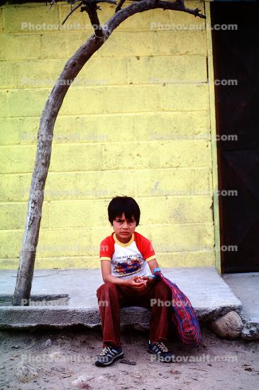 Boy Sitting on a sidewalk, curb, Colonia Flores Magone