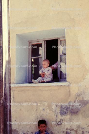baby in a window sill, building