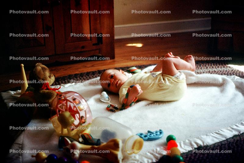 Baby laying down, toys, cute, blanket, Baby in a Onesie, 1960s