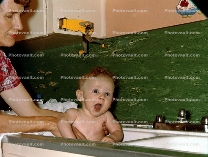 Cute Baby in a Kitchen Sink Bath, Mother