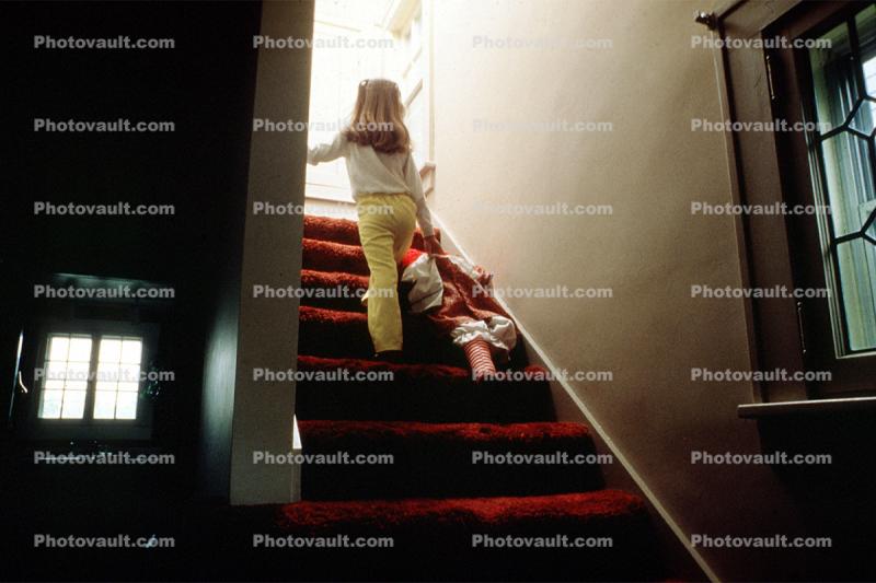 Girl walking upstairs with a Doll