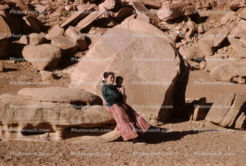 Navajo Woman with Baby, sandstone boulders, Sand, Desert