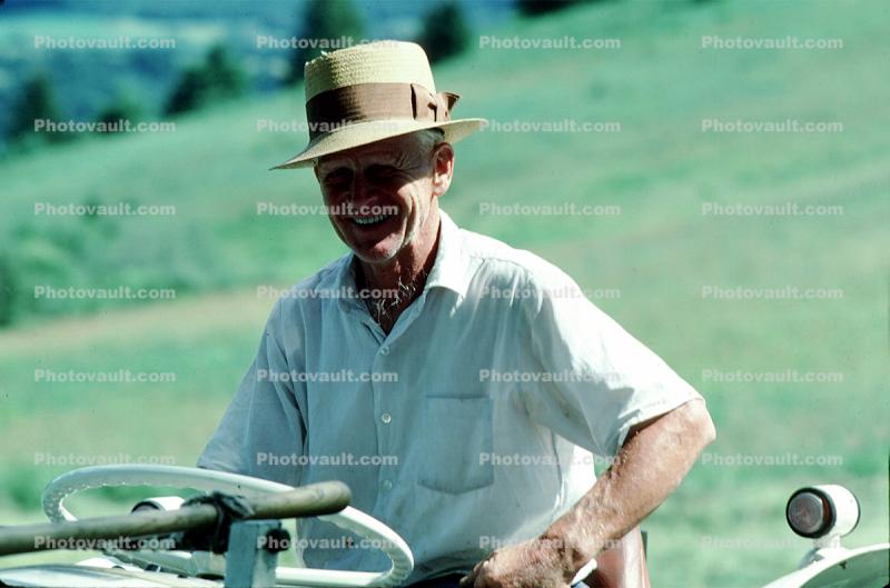 Smiling man with his tractor, Burklyn, Burke, Vermont, 1970s
