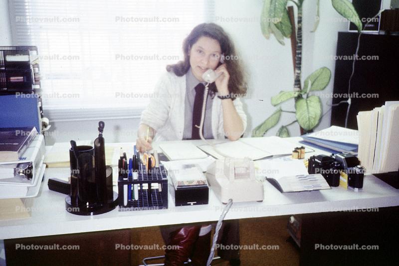 Woman talking on a telephone, desk