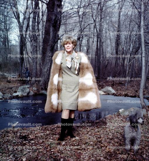 Woman shows off her fur coat and dress, Poodle, forest, winter, cold, May 1967, 1960s