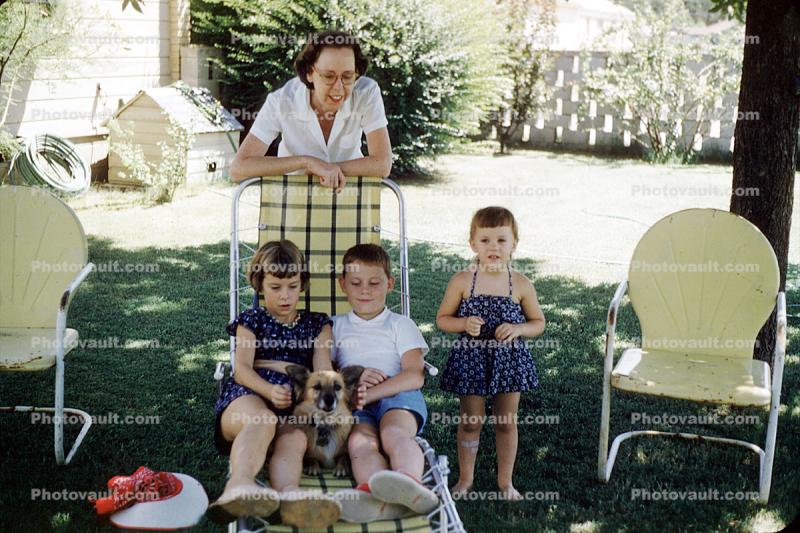 Backyard, mother, sister, brother, siblings, lawn chair, doghouse, 1950s