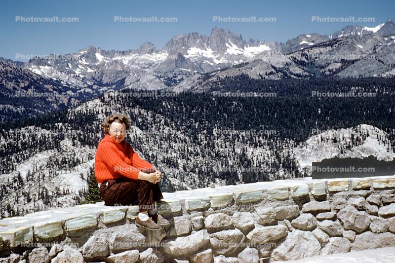 Woman sitting on a wall, sweater, mountains, 1950s