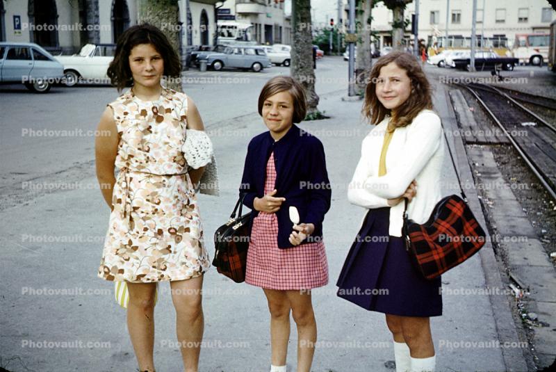 Girls, curb, sidewalk, tracks, smiles, smiling, skirts, dress, flowery, floral, 1960s