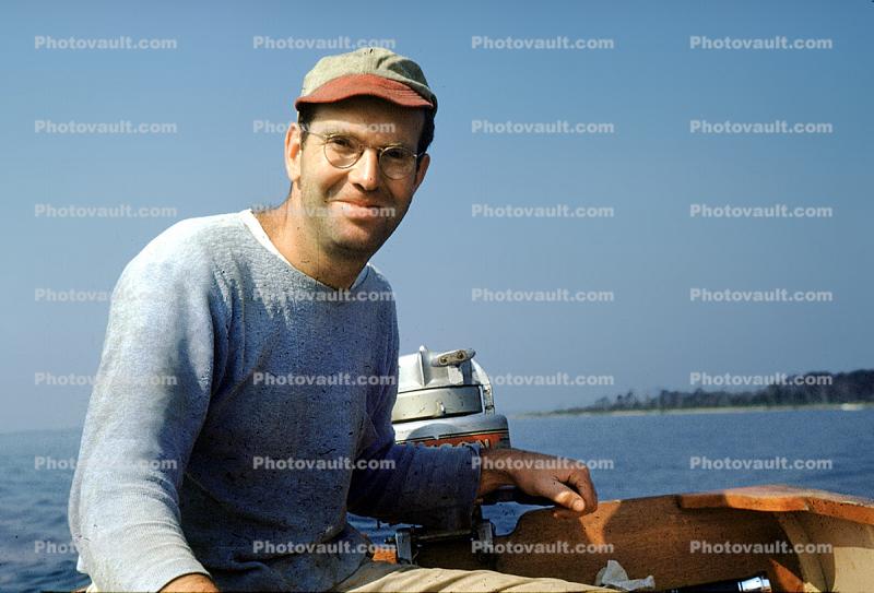 Man on a Motorboat, smiles, glasses, cap