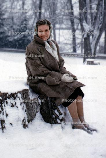 Woman Sitting in a Snowy Park, Bare Trees, Cold, Ice, Coat, Winter, Smiles, 1950s