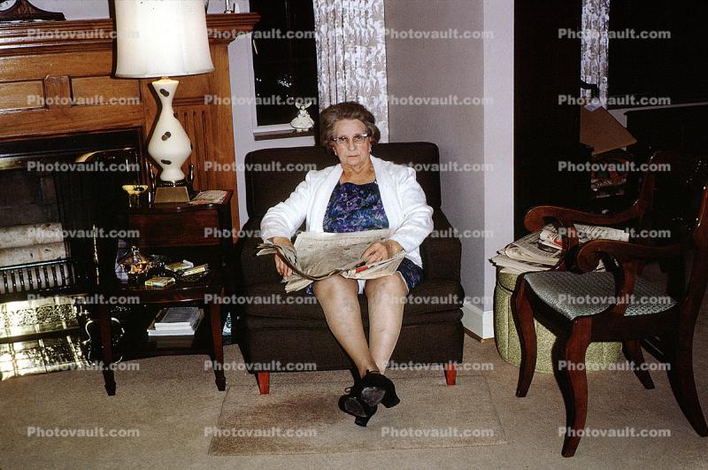 Woman reading the newspaper, lamp, chair, October 1965, 1960s
