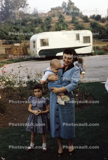 Woman with baby son, daughter, trailer, dress, 1950s