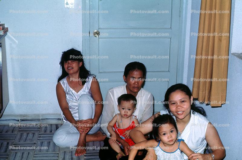 Asian Family sitting on the floor, man, woman, children