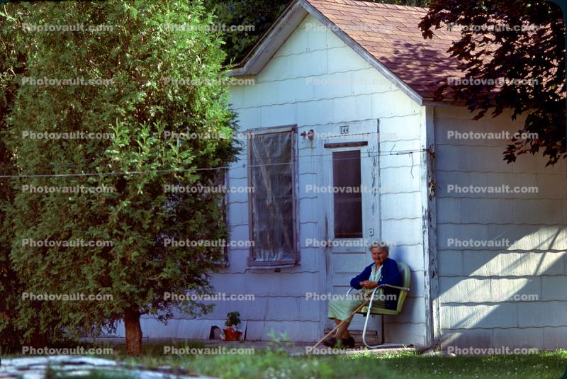 Senior Woman sitting, cane, house