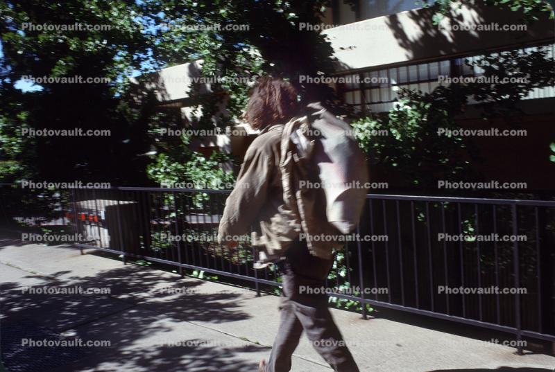 Homeless man walking, knapsack