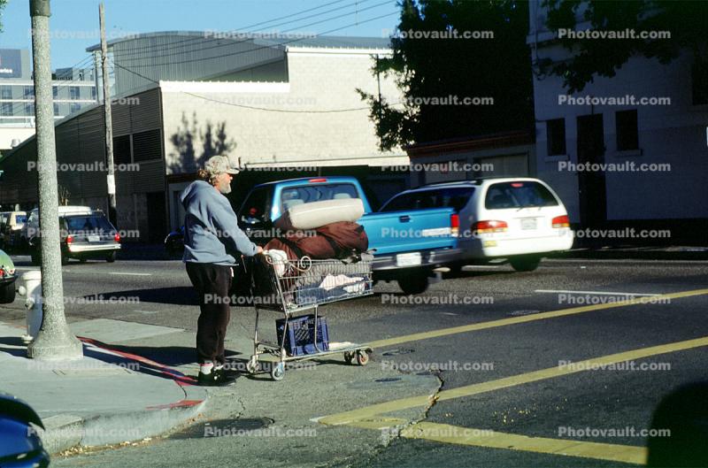 Homeless Man with a shopping cart, crosswalk, street, car