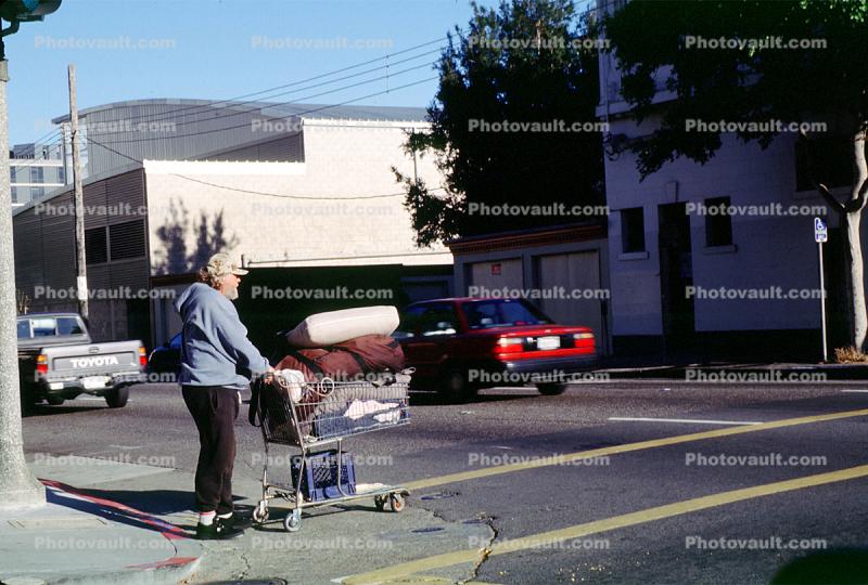 Homeless Man with a shopping cart, crosswalk, street, car