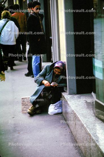 Homeless Woman Sitting at a Sidewalk