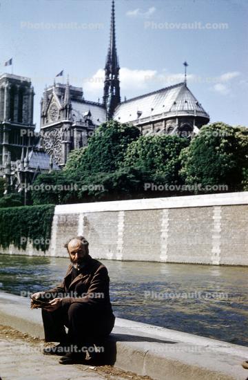 Homeless Man sits along the River Seine, Paris