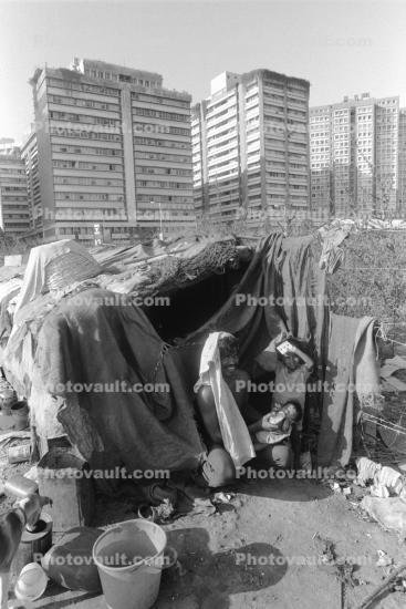 Man, baby, proud father, Shanty Home, Shack, apartment buildings, slum, Mumbai, India