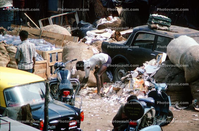 Man recycling paper, trash, slums, cars, Nariman Point, Mumbai, India