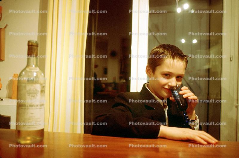 young boy drinks hard liquor