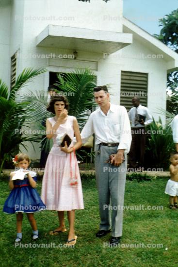 finished a church service, building, lawn, daughter, mother, father, bible, dress, sandals, the Pariers, 1950s