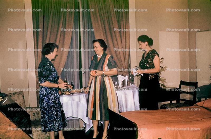 Women having dinner in a hotel room, bed, table setting, curtains, formal dress