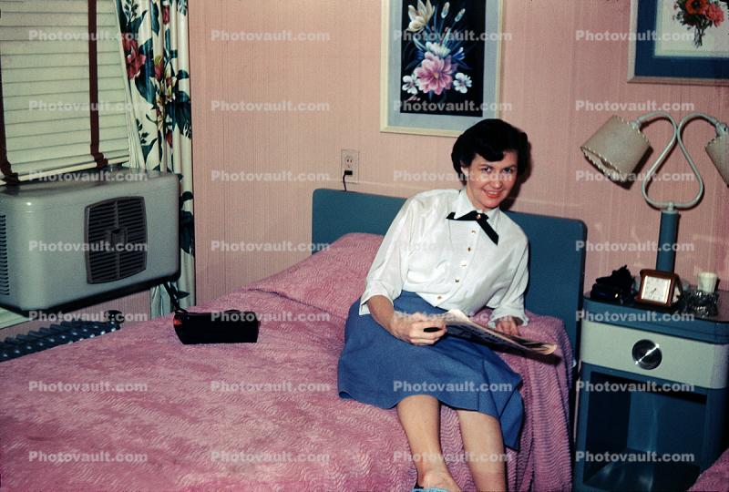 Woman in  Hotel Room, smiling, bed, lamp, air conditioner, 1950s