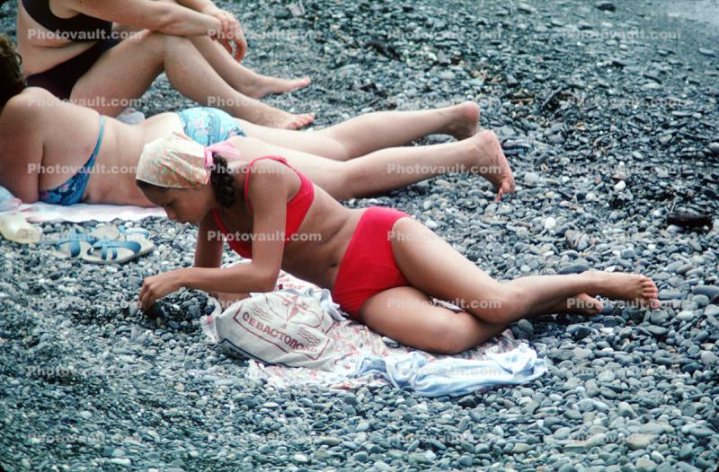 Teen Bikini Girl playing with pebbles and rocks, beach, 1980s