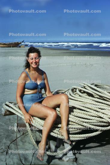 Woman sitting on a Coil of Rope, Beach