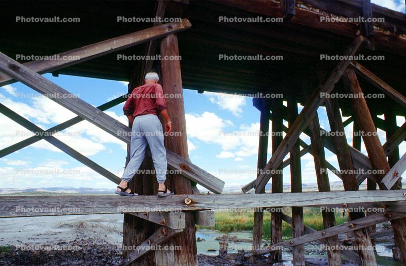 Man walking on a wooden beam, Train Trestle