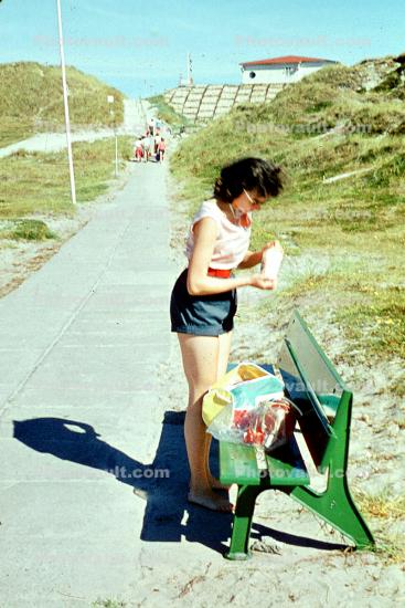 woman in shorts, bench, 1950s