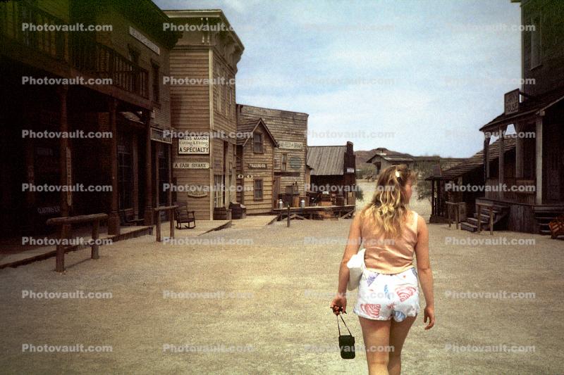 Woman Walking down the Street, old western town, wildwest, frontier village, 1968, 1960s