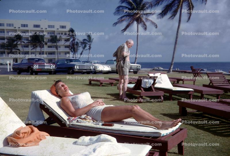 Woman, lounging, lounge chairs, lawn, cars, 1950s